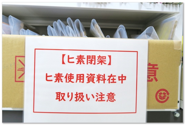 閉架書庫のダンボールに貼られた「ヒ素閉架」の写真