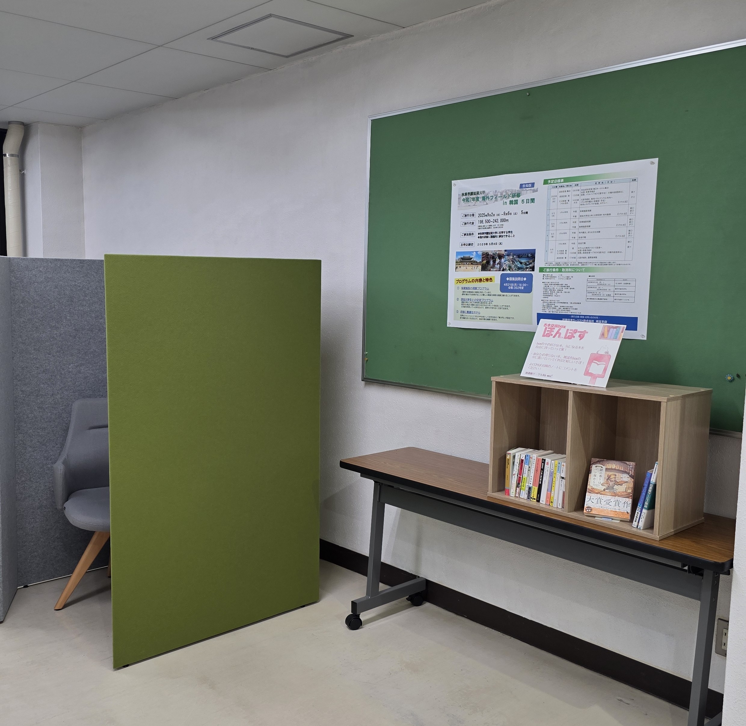 ほんぽすが設置された写真。机の上に２段のカラーボックスを横置きし、その中に交換用の古本が入っている。