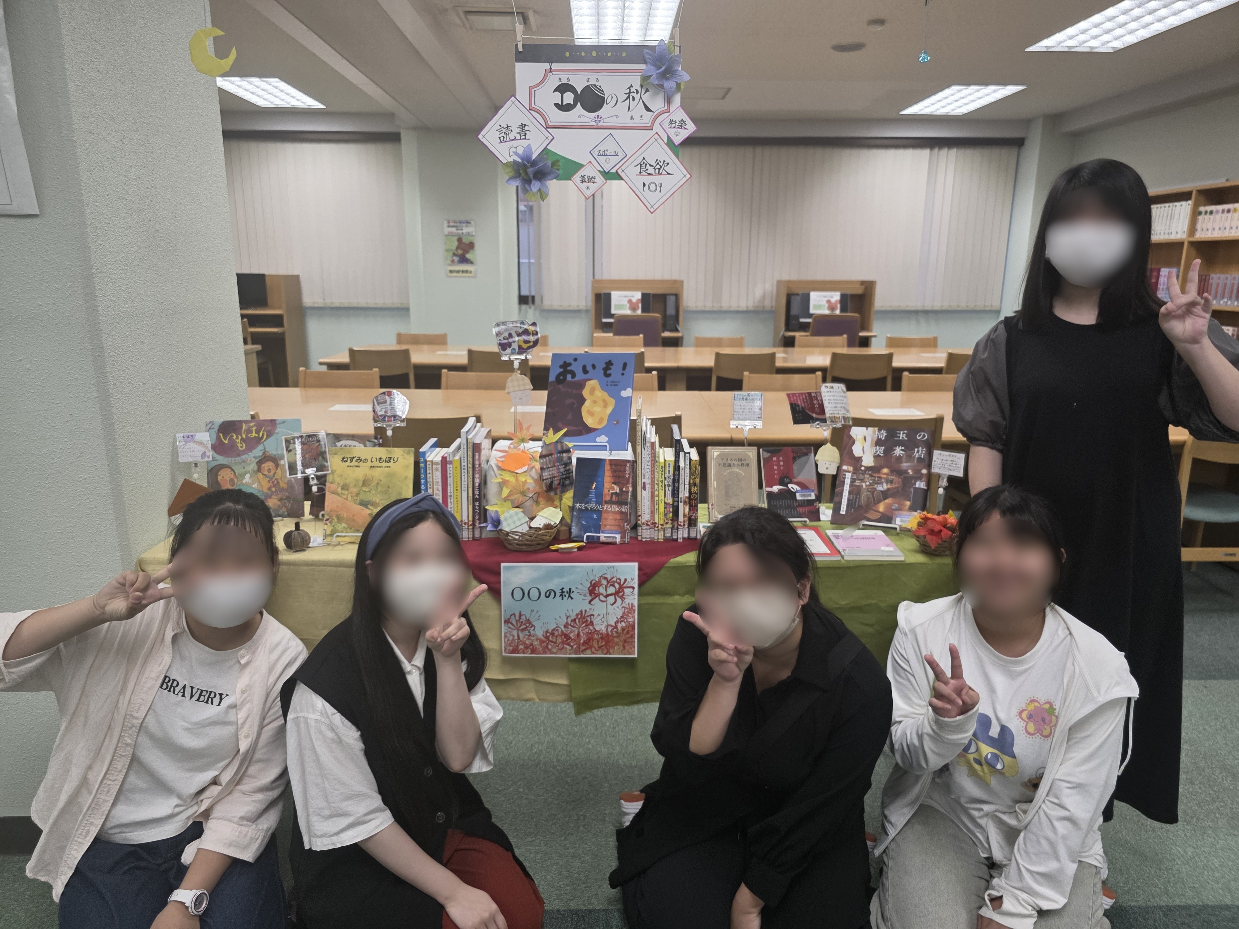 「○○の秋」の展示の様子。食欲の秋、運動の秋、芸術の秋などをテーマにした秋らしい装飾の展示を行った。展示の前にメンバーが記念撮影をした。
