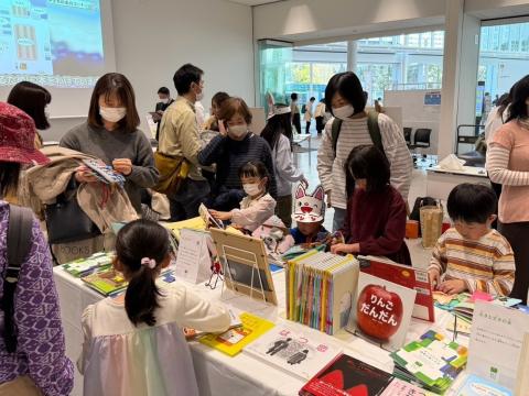 読書バリアフリー体験会の様子。参加者がテーブルに並んださまざまなアクセシブルな図書を手に取り、見たり触れたりしながら体験している。
